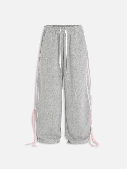 Pantalón baggy con bandas rosas y lazos laterales