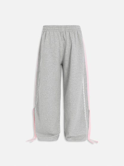 Pantalón baggy con bandas rosas y lazos laterales