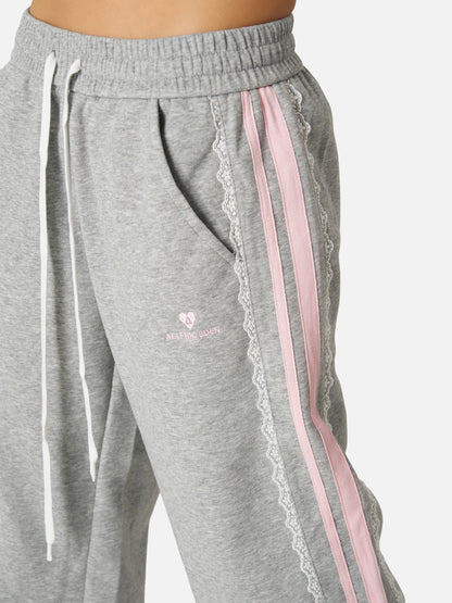 Pantalón baggy con bandas rosas y lazos laterales