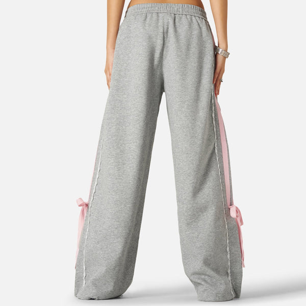 Pantalón baggy con bandas rosas y lazos laterales